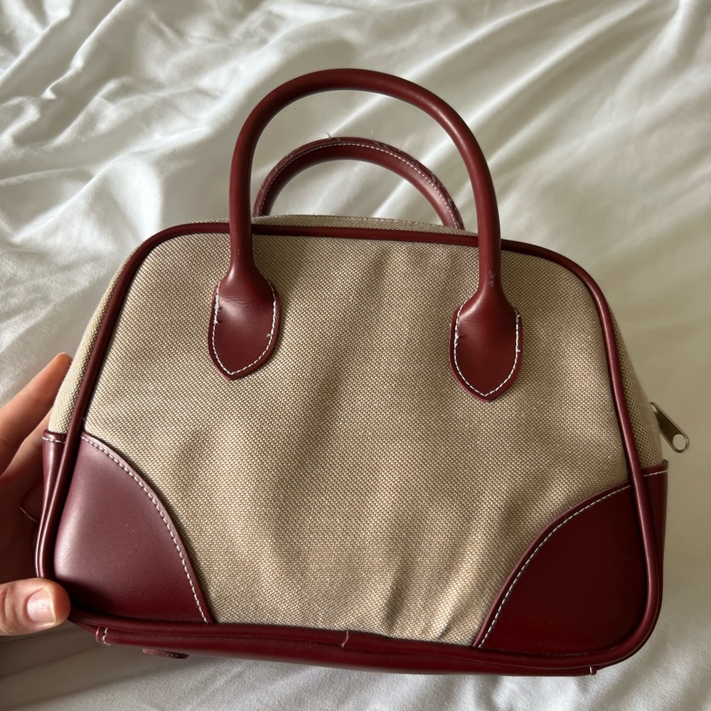 Canvas handbag with red leather accents.
